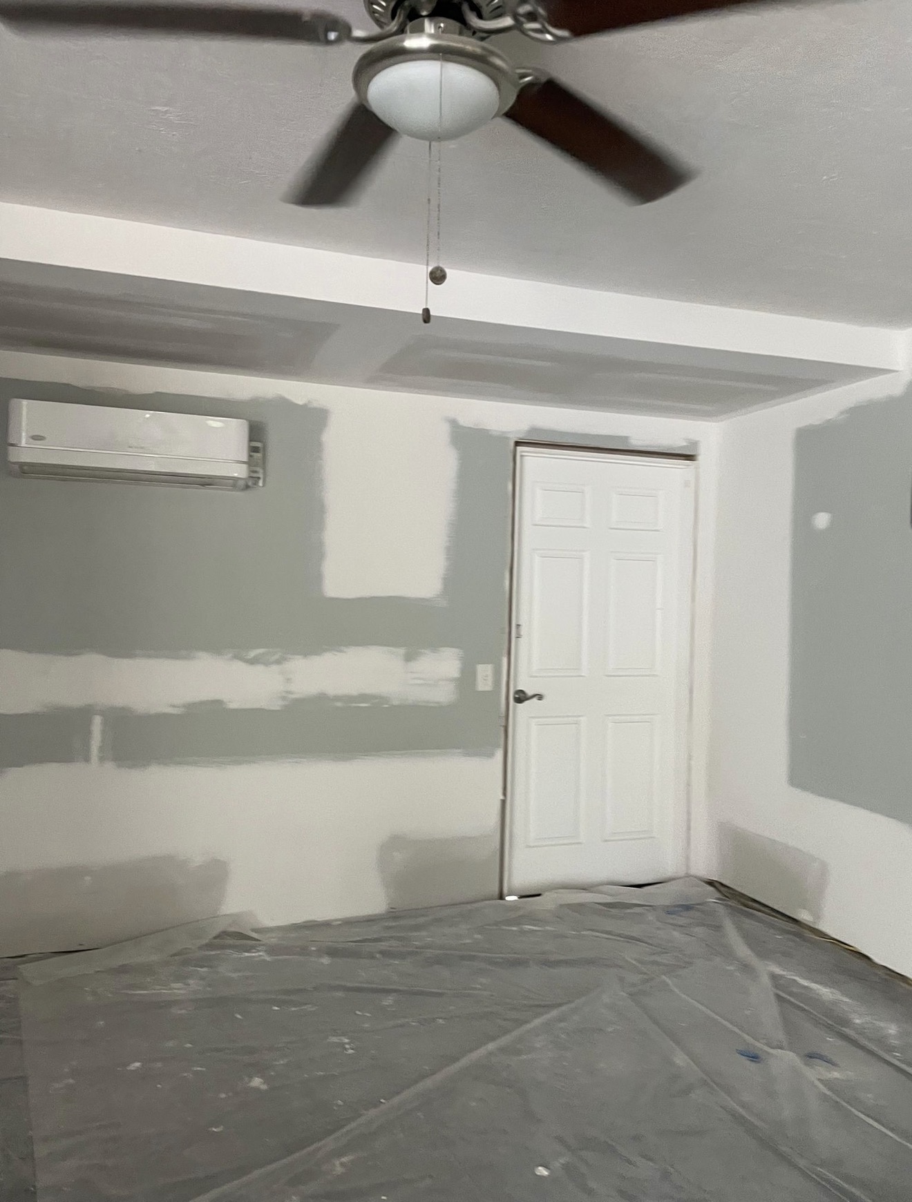 Room with repaired drywall and ceiling ready for finishing