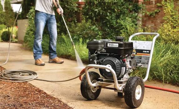 Professional pressure washing a residential driveway